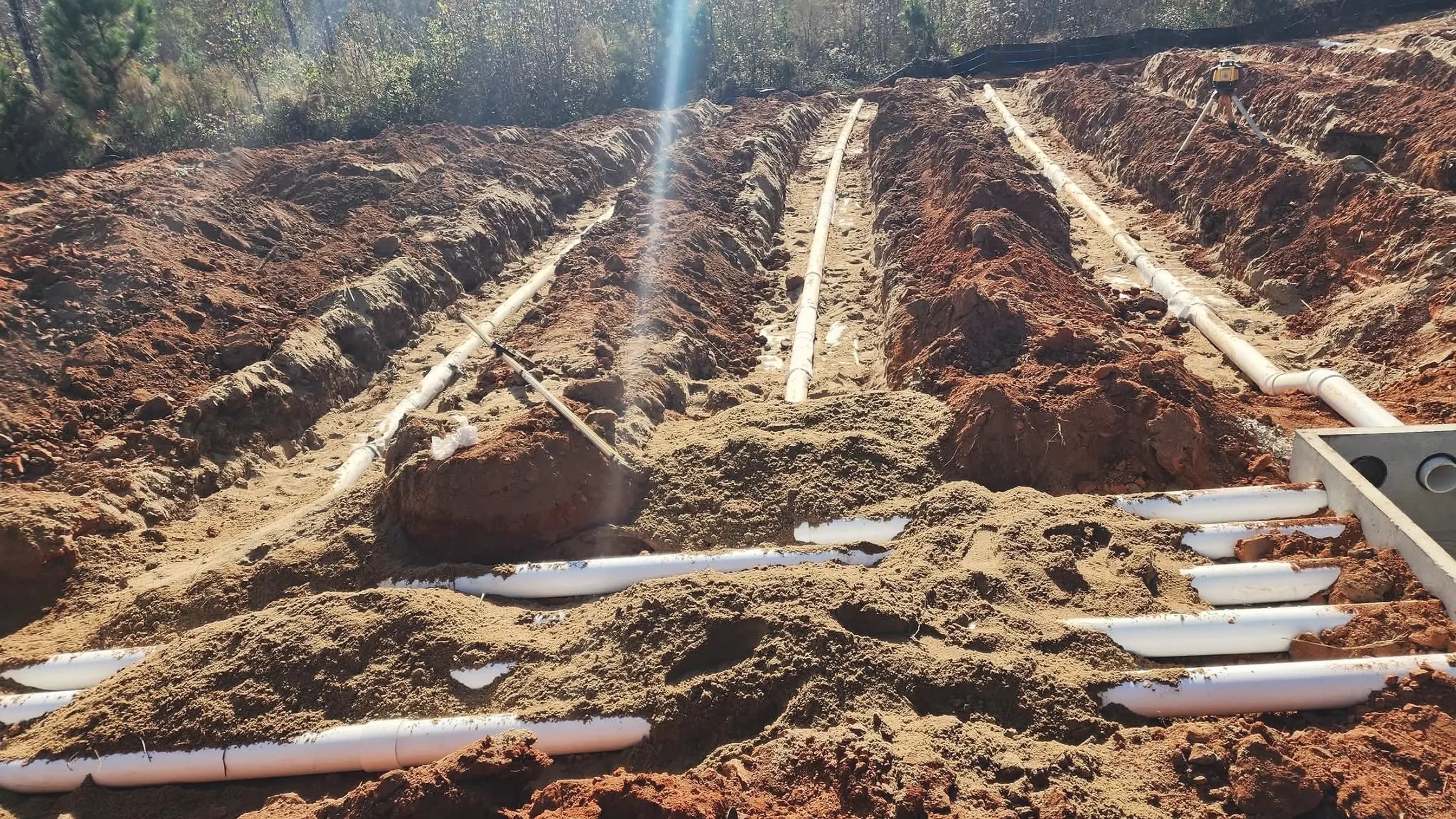 From our job files: parallel drain field trenches with PVC laterals feeding a concrete distribution box; illustrating septic repair for Monroe, Georgia