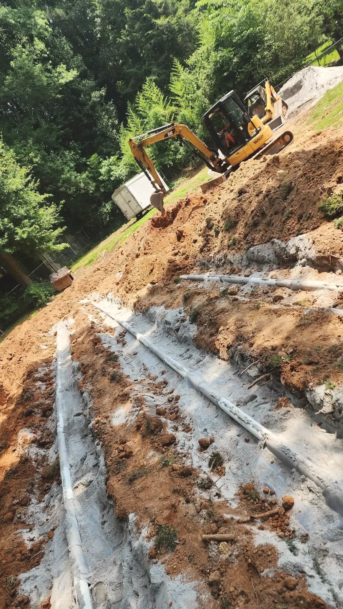 Drain field repair: gravel lines and a mini excavator.