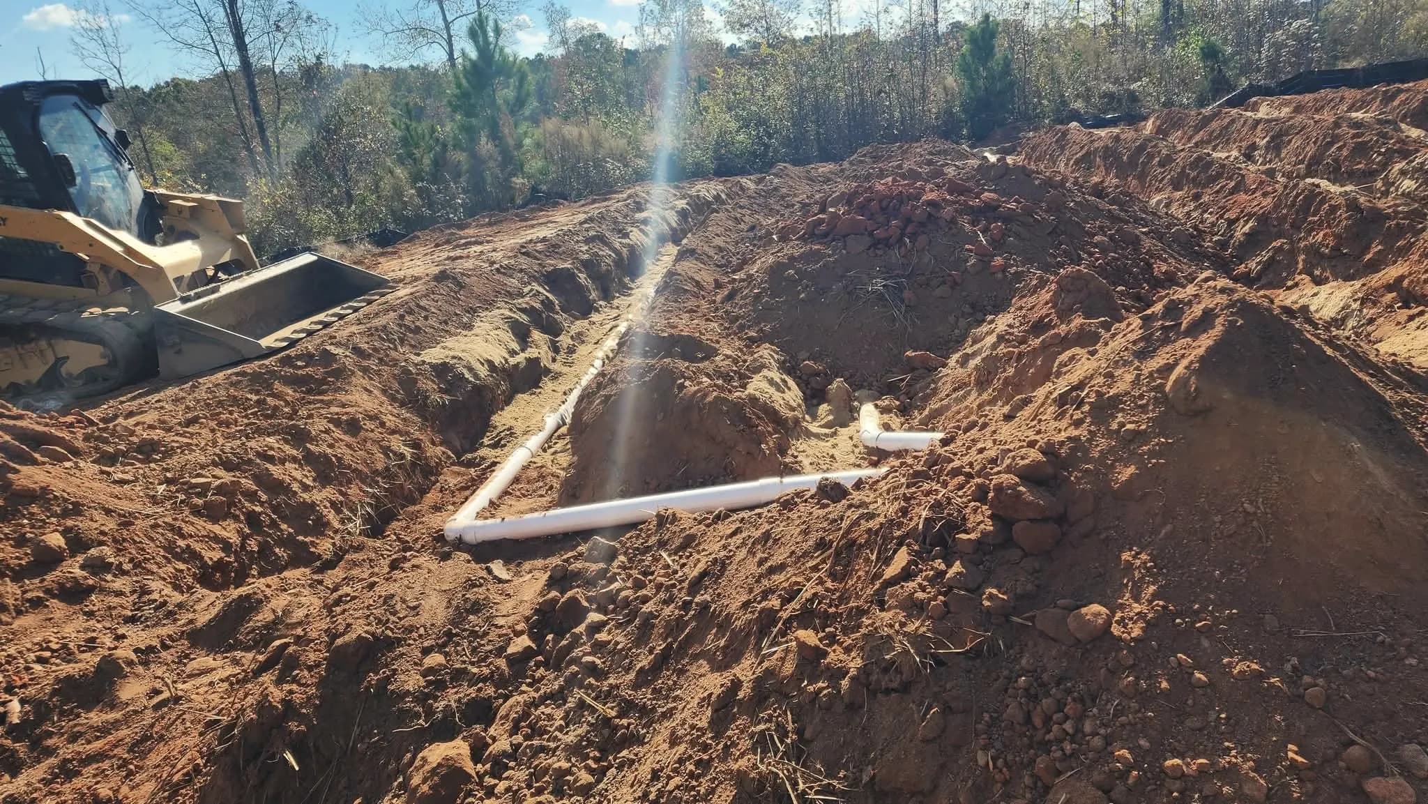 Drain field trenches with PVC distribution lines.