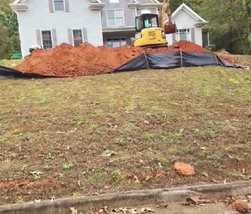 Front-yard excavation behind silt fence.